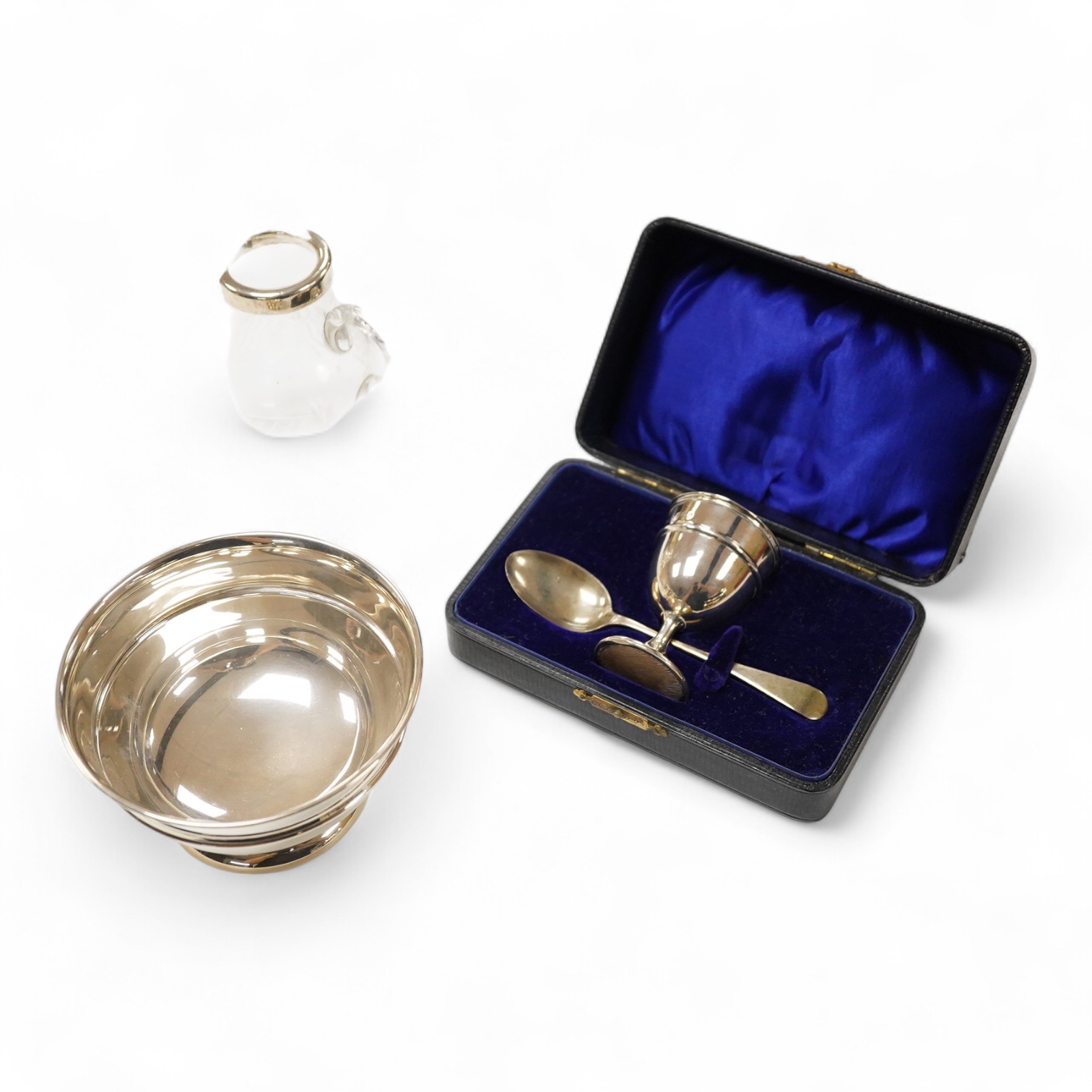 A George VI silver sugar bowl, Viners Ltd, Sheffield, 1946, diameter 10.9cm, together with a cased silver spoon & pusher and a silver mounted glass liquor jug.